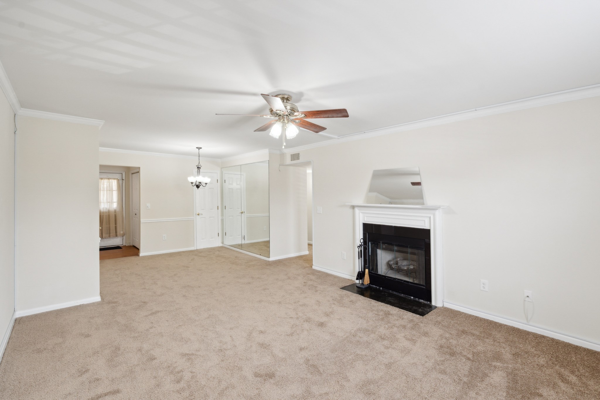 an empty room with a fireplace and a ceiling fan