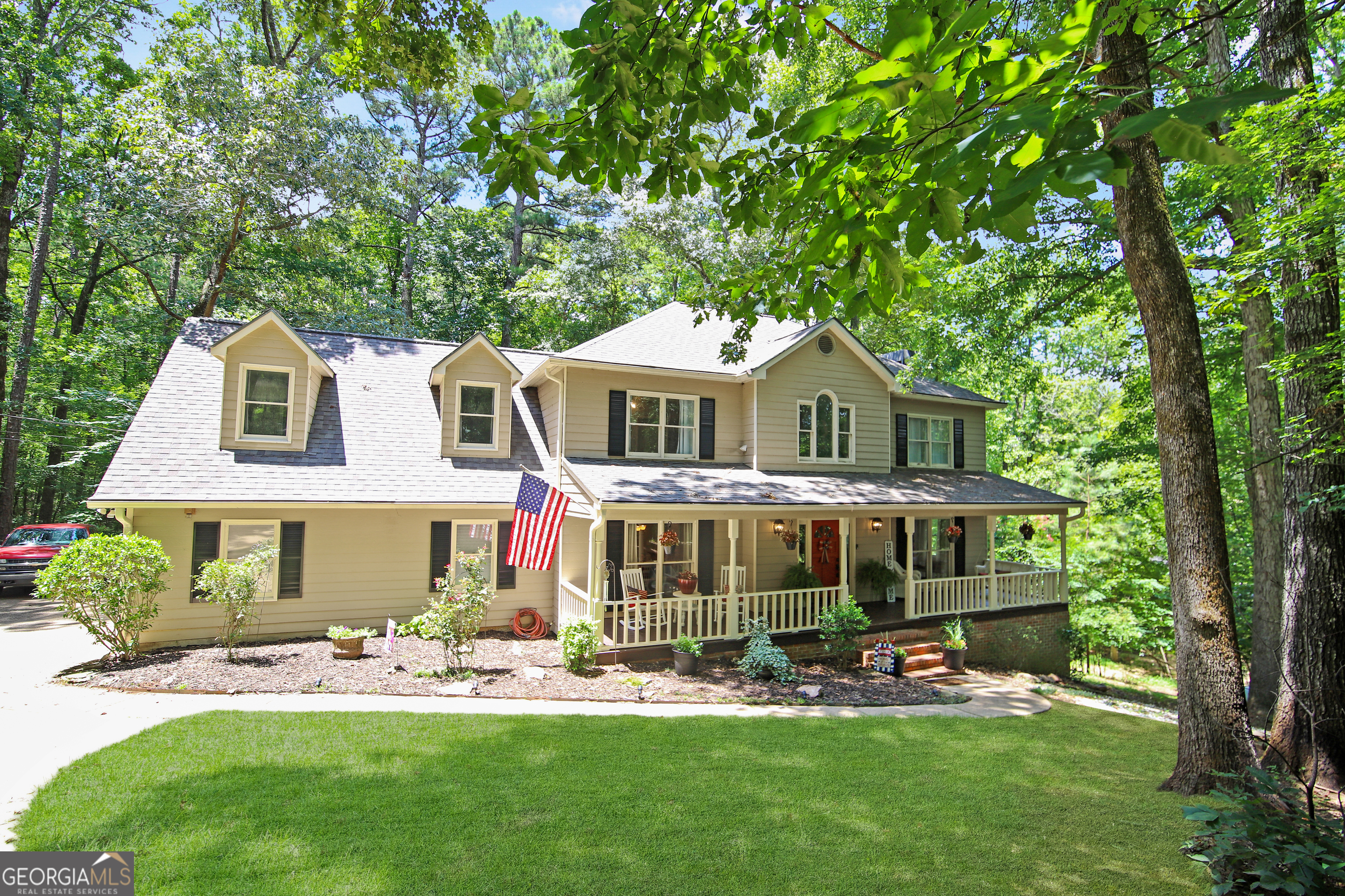 a front view of a house with garden and sitting area