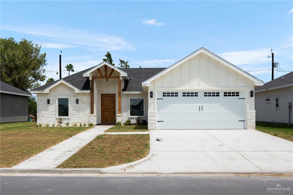 View of front of property featuring a garage and a front lawn