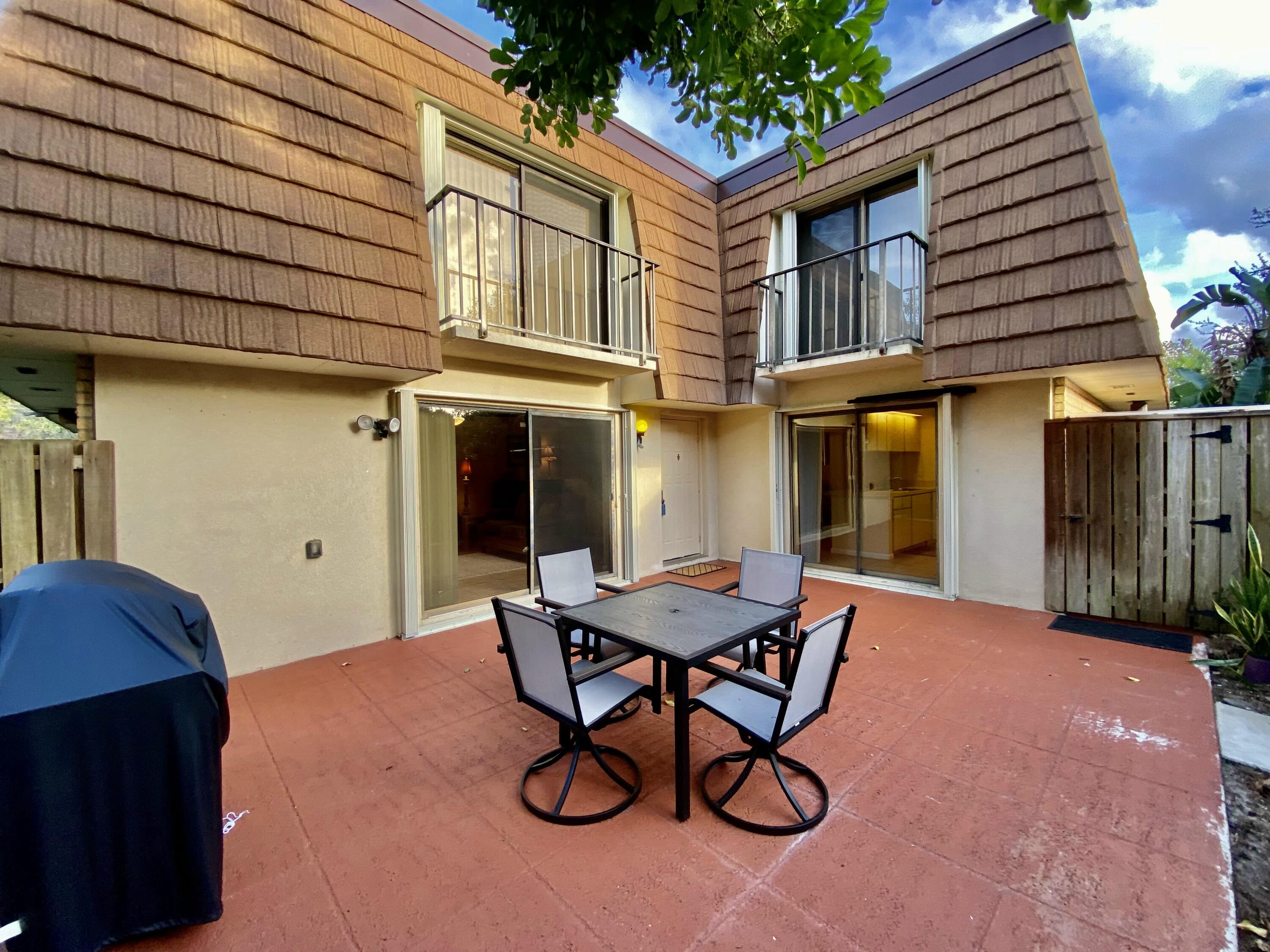 a backyard of a house with table and chairs