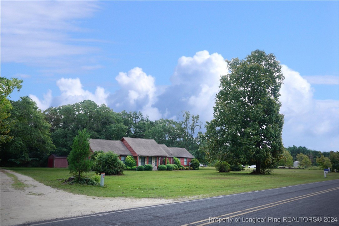 a view of a green field with house in the background