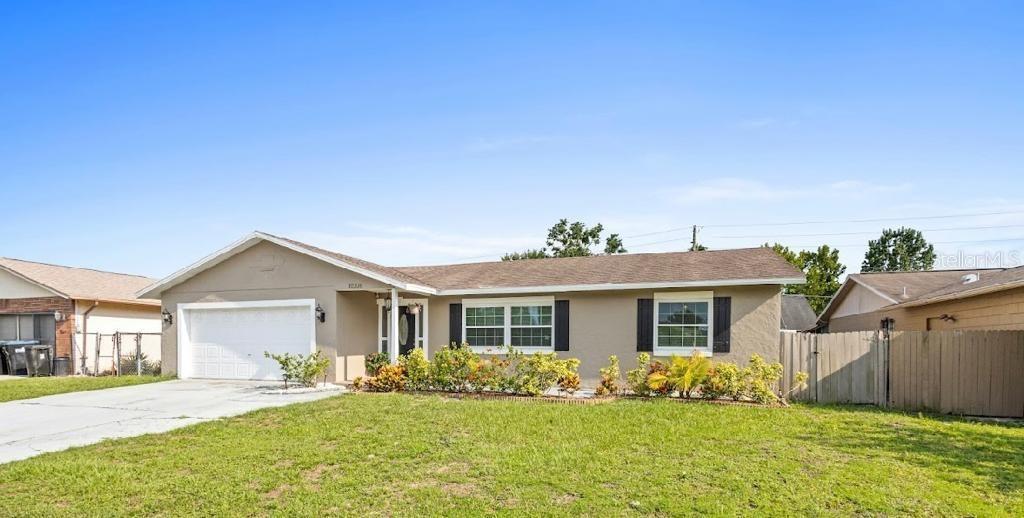 a front view of a house with a yard and potted plants