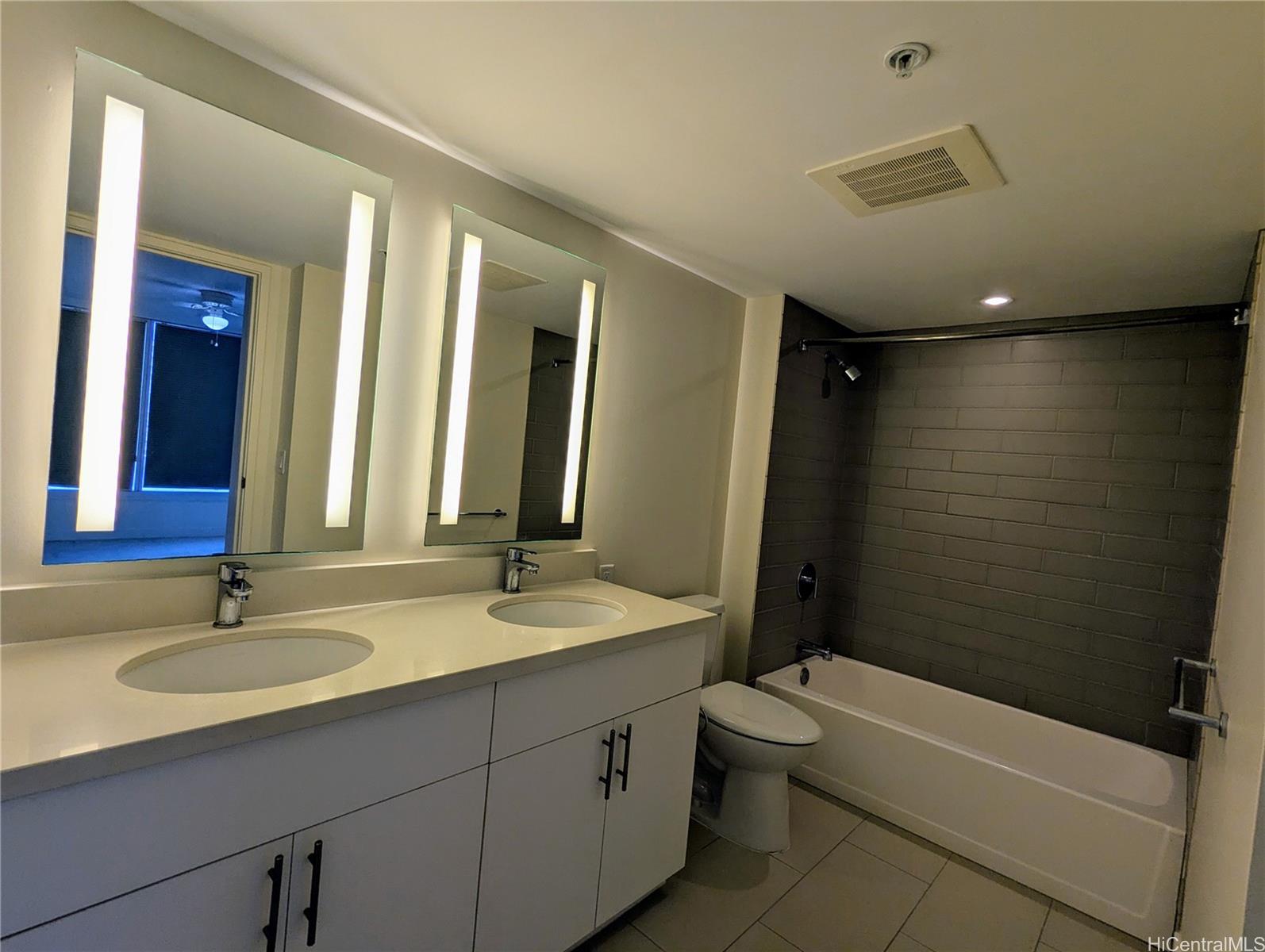 a bathroom with a double vanity sink toilet mirror and bathtub