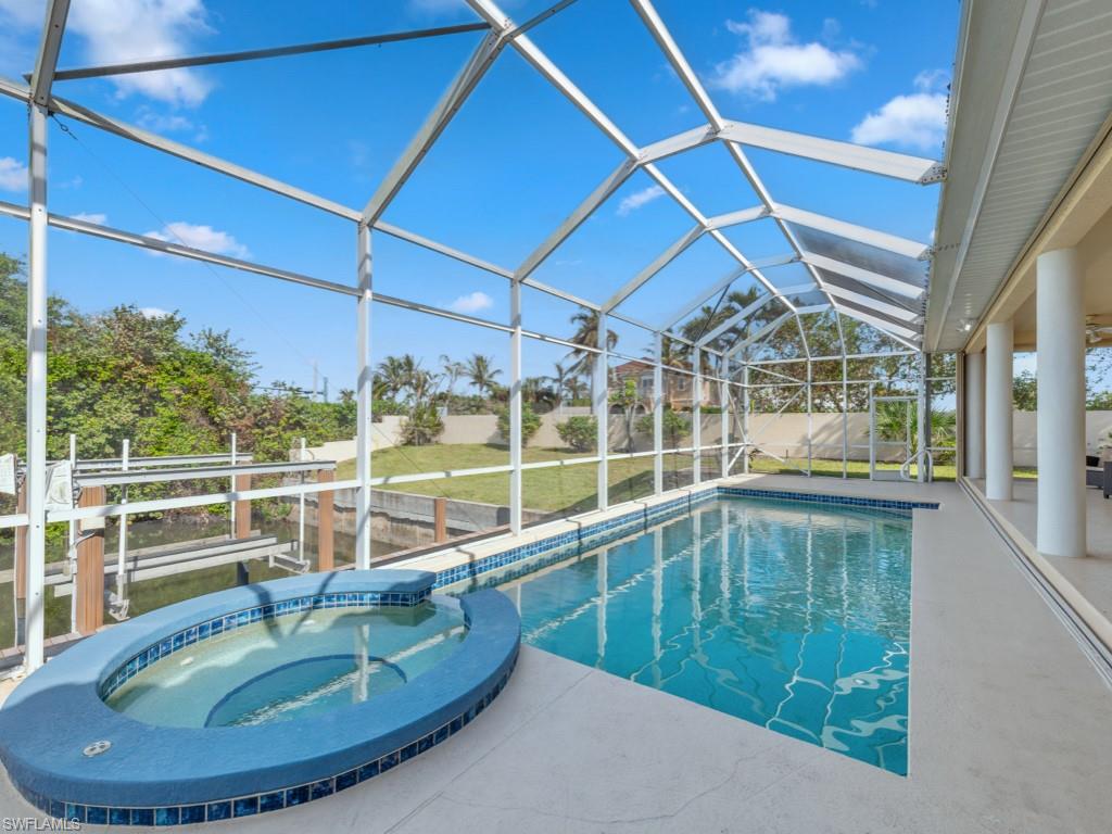 View of swimming pool featuring a patio area, a lanai, and an in ground hot tub