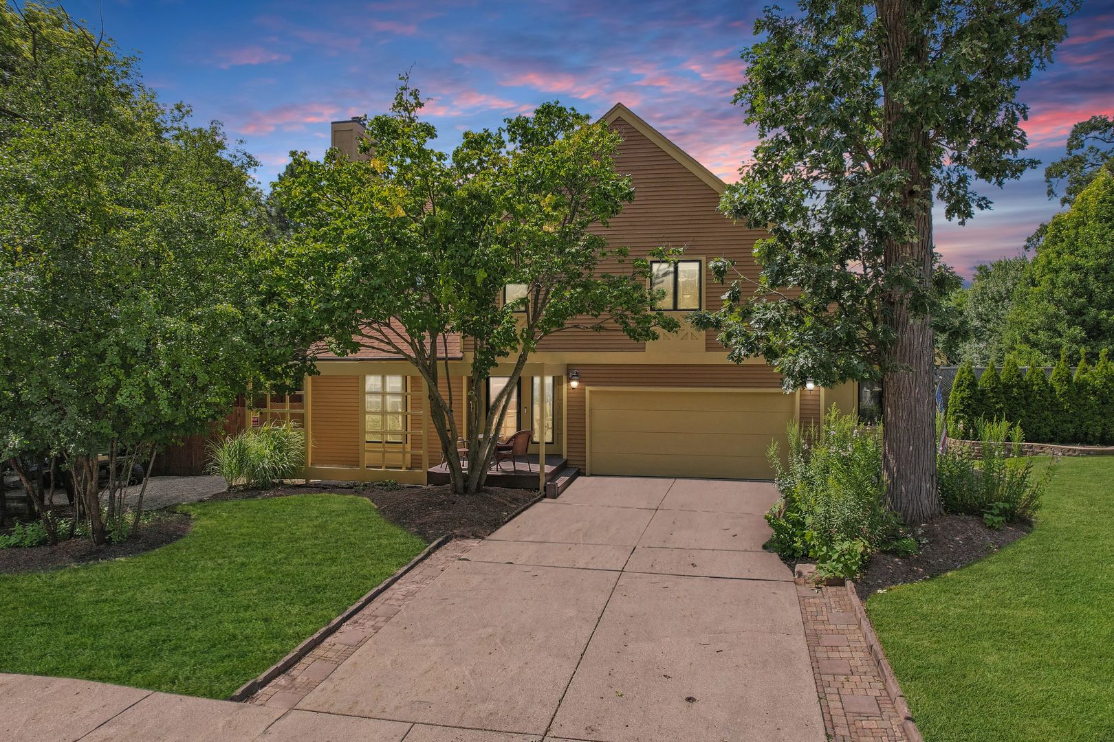 a front view of a house with a yard and trees