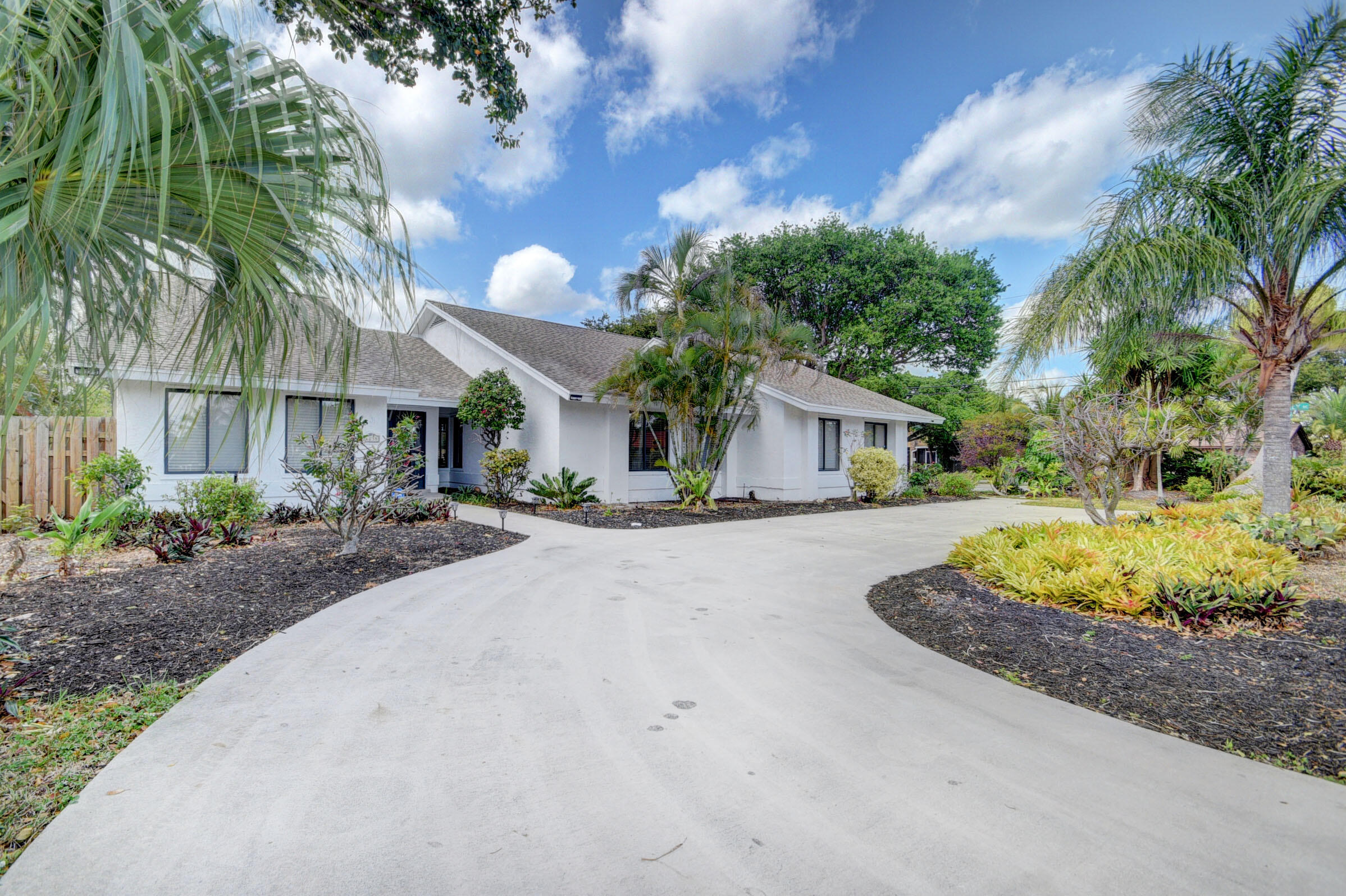 a front view of a house with a yard and potted plants