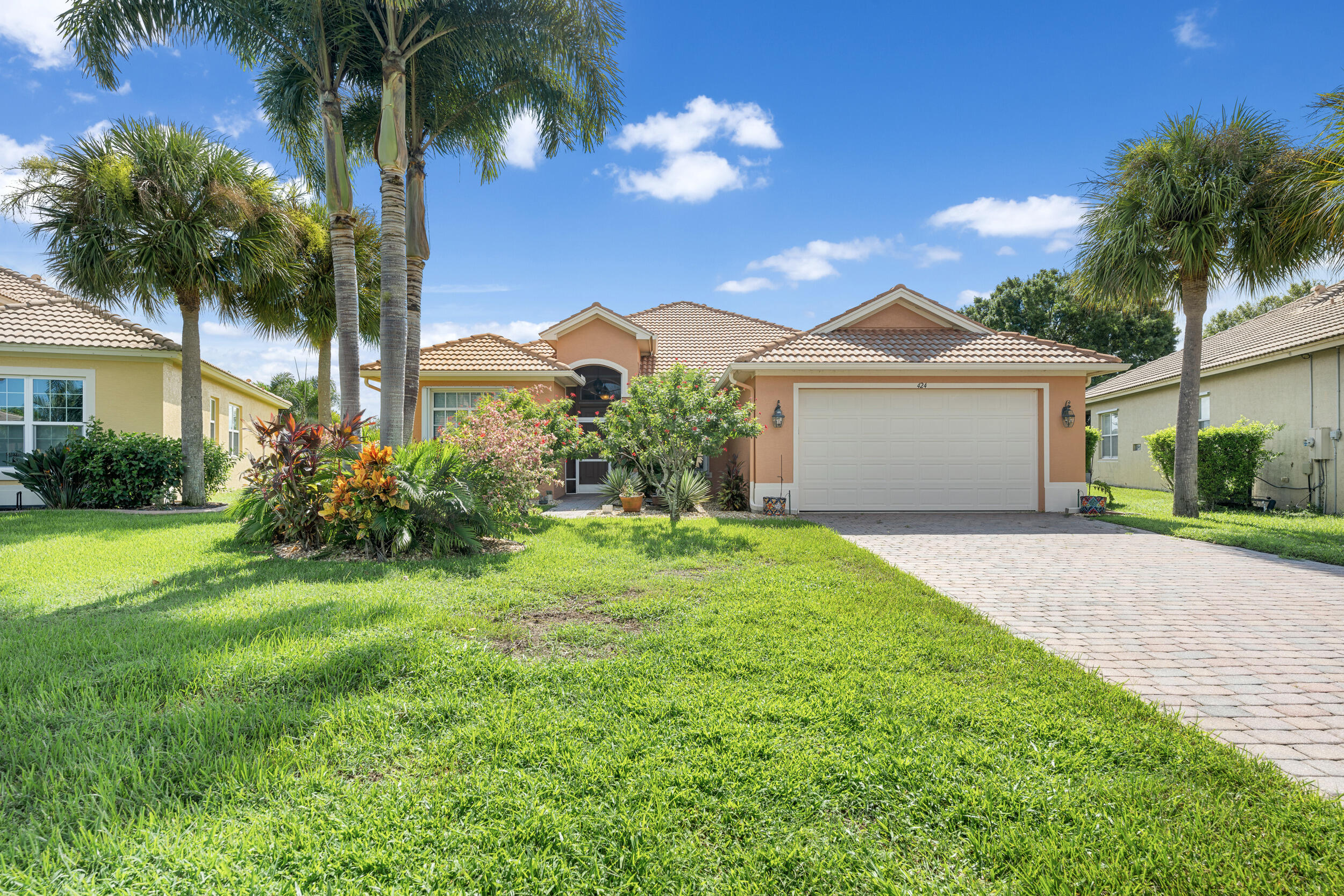 a view of a house with a yard and palm trees