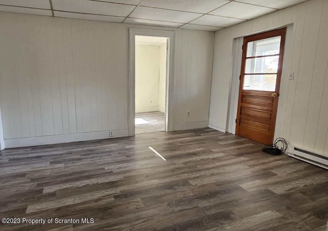 a view of an empty room with wooden floor and closet