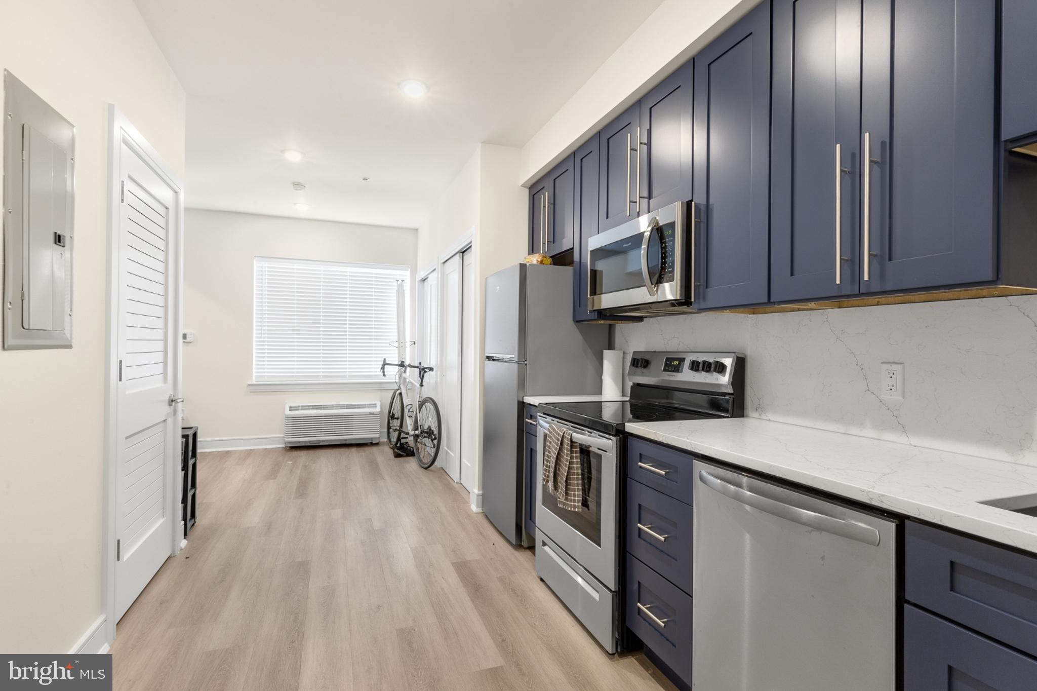 a kitchen with stainless steel appliances granite countertop a stove refrigerator and cabinets