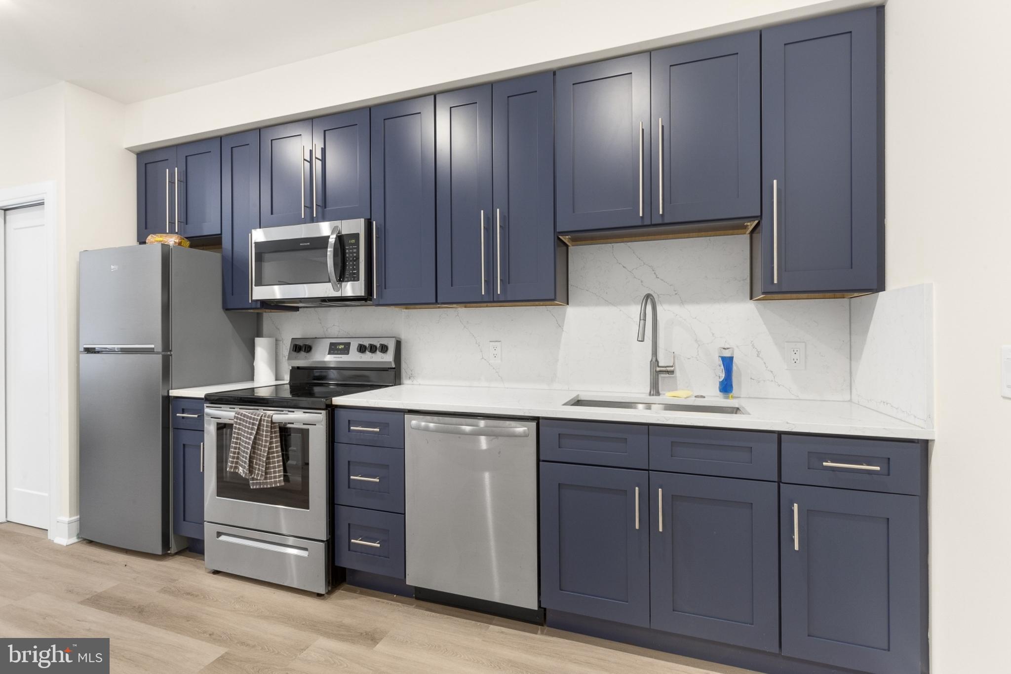 a kitchen with sink a microwave and refrigerator