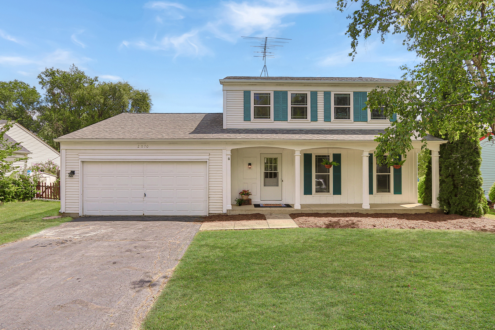 a front view of a house with a garden and yard