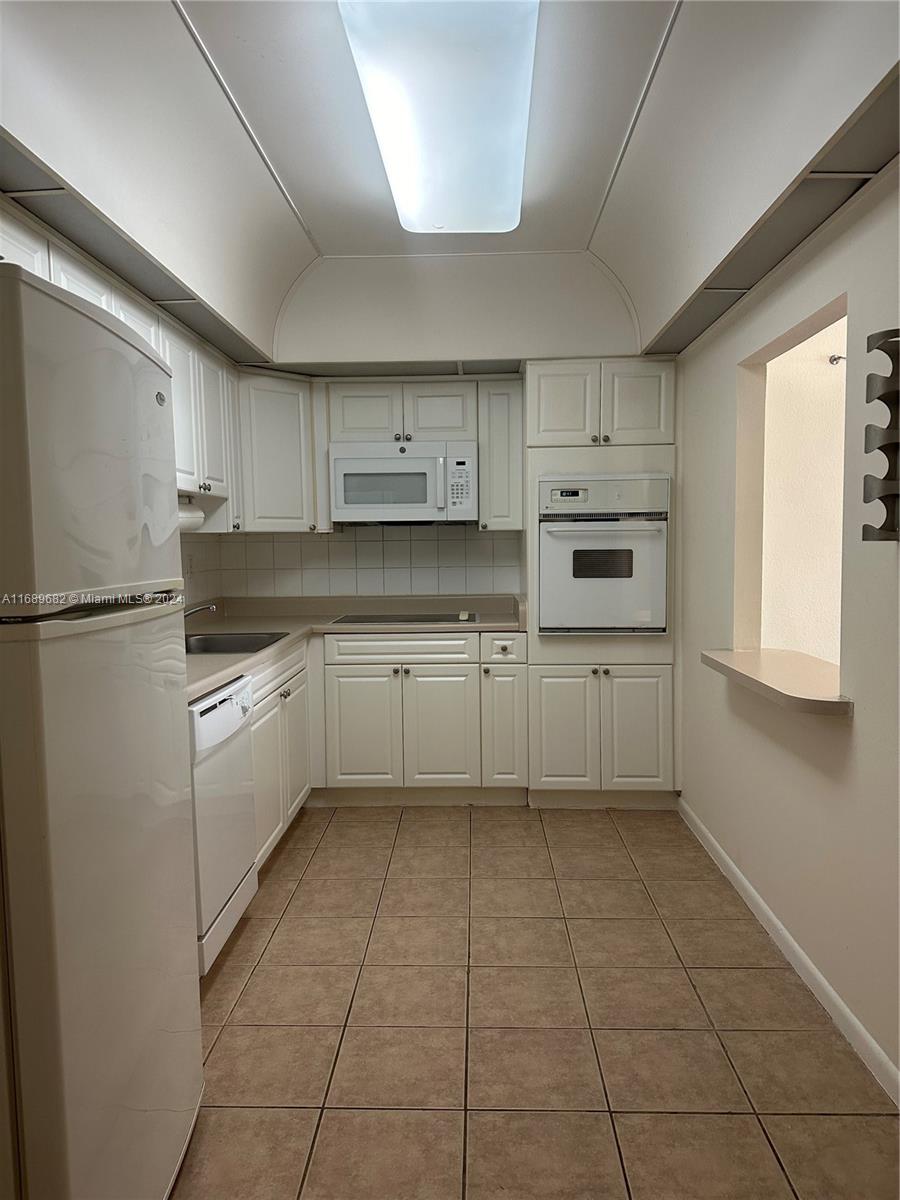 a kitchen with cabinets oven and a sink