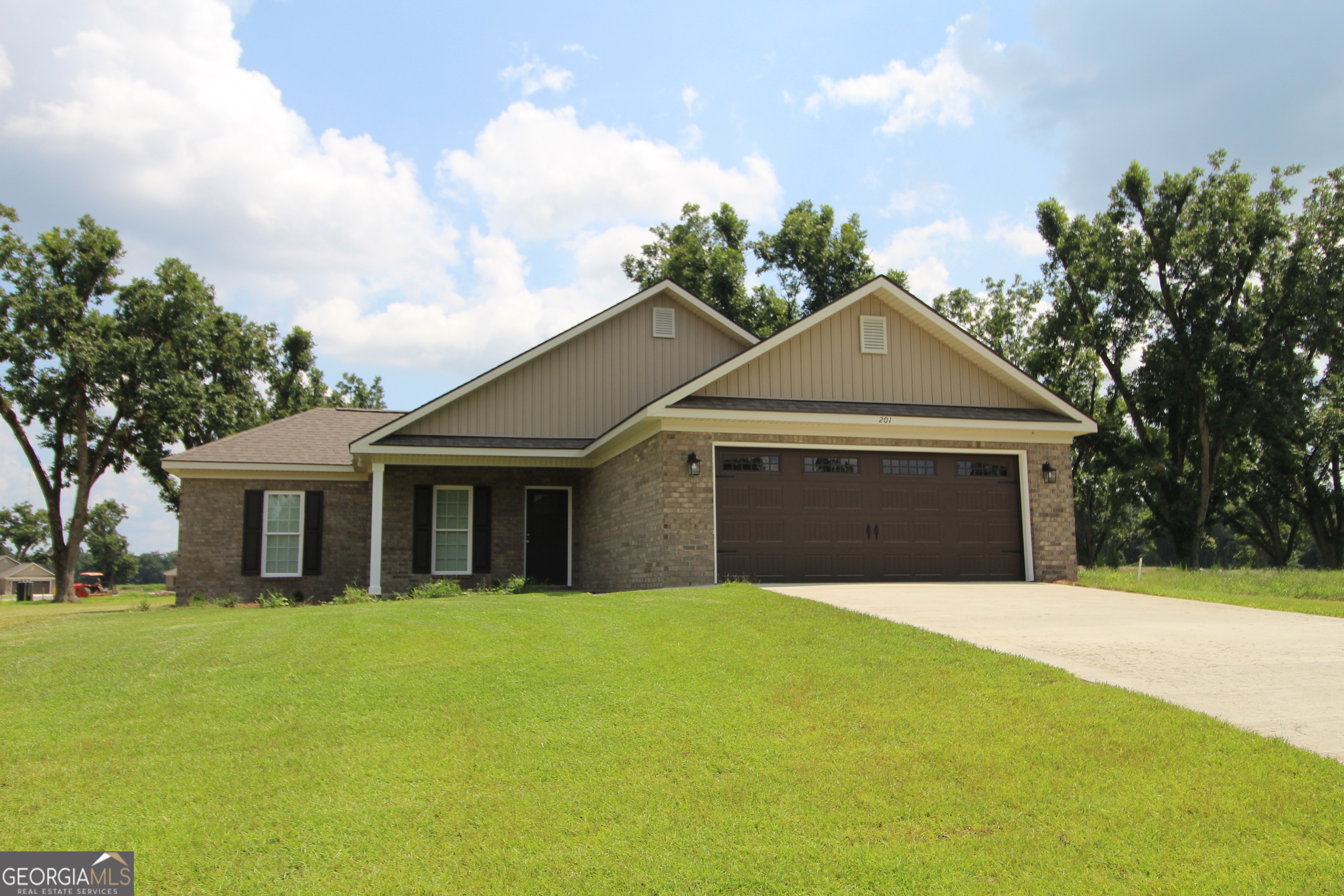 a front view of a house with yard and garage