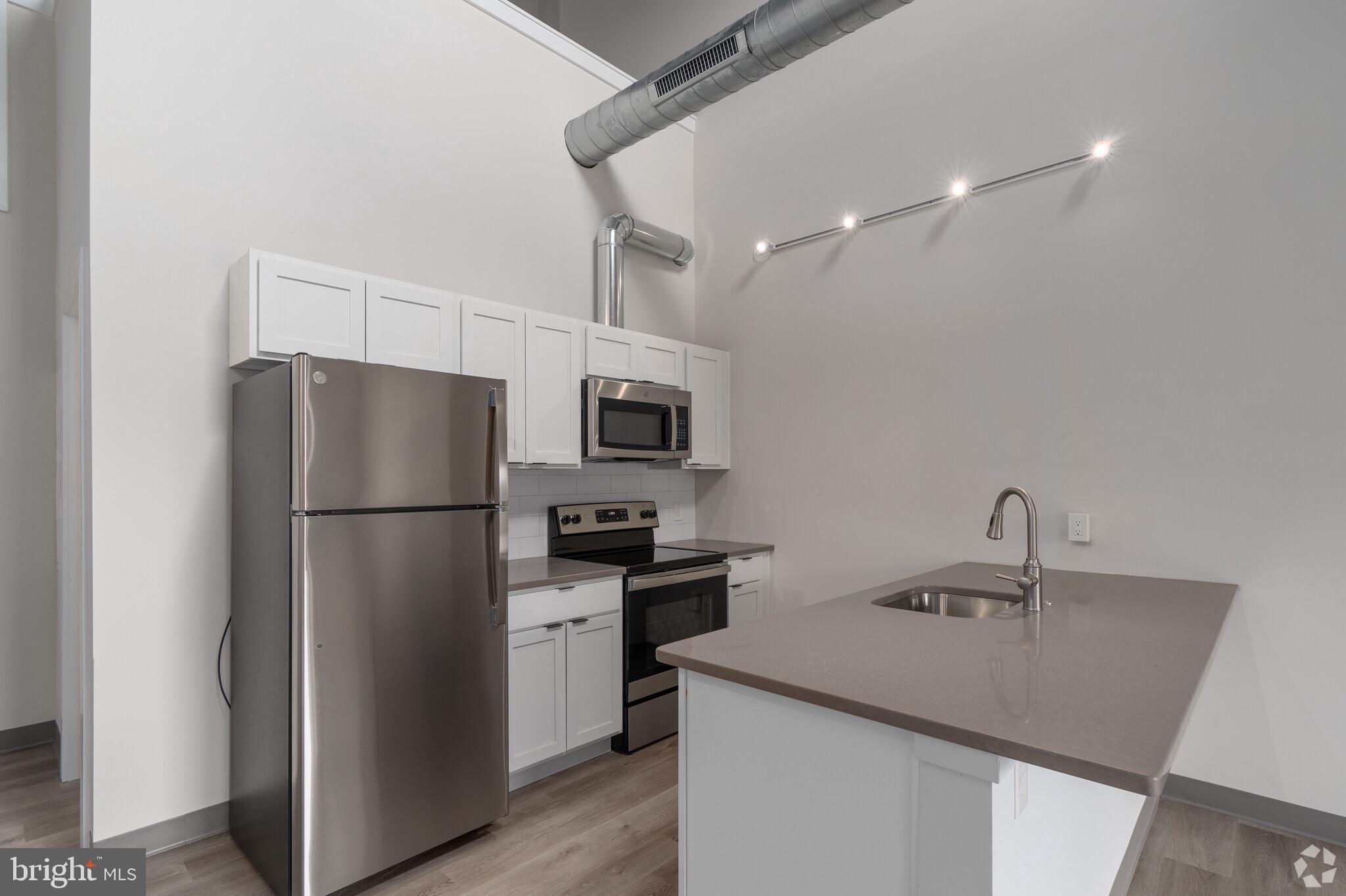 a kitchen with stainless steel appliances a refrigerator sink and microwave