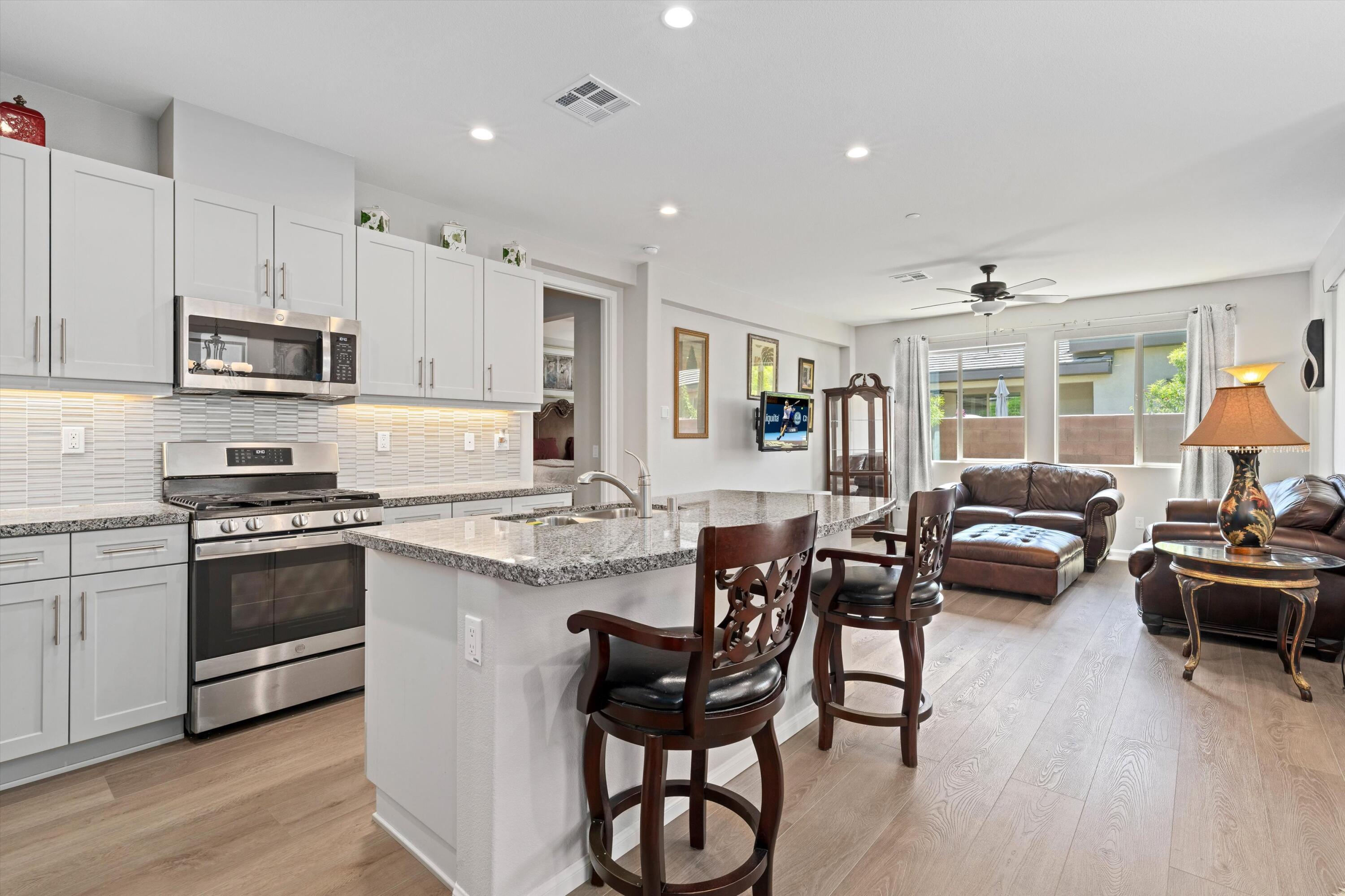 a kitchen with kitchen island granite countertop wooden floors and stainless steel appliances