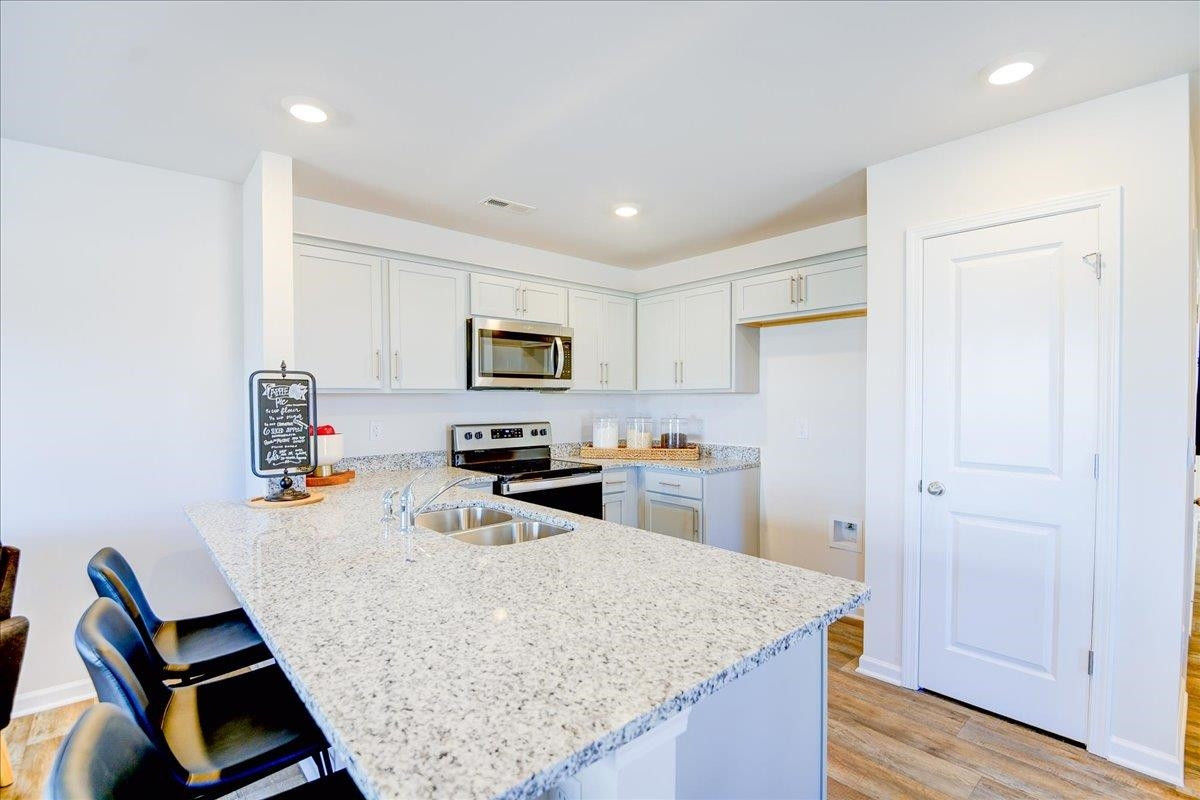 a kitchen with stainless steel appliances granite countertop a sink refrigerator and microwave