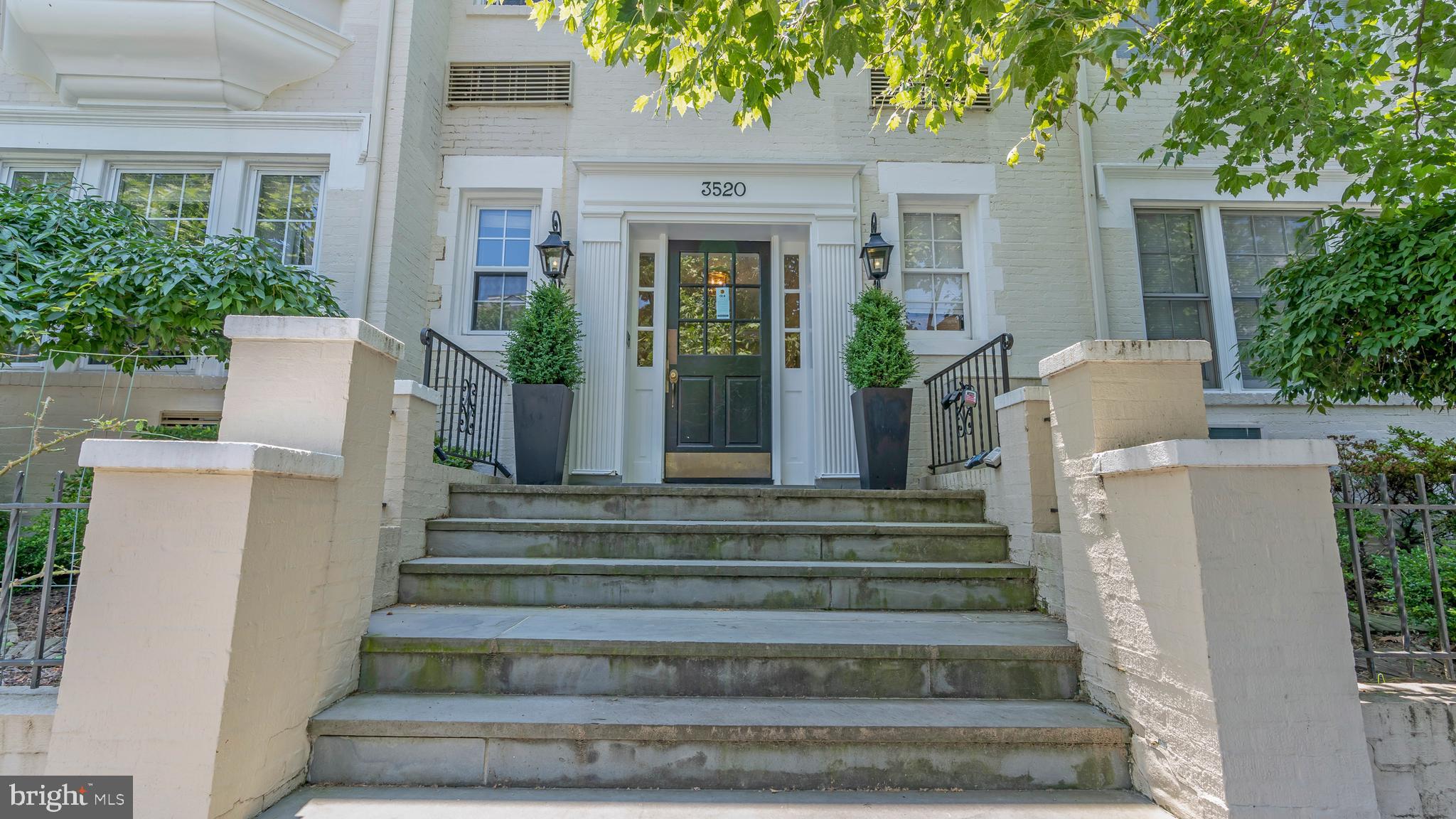 a front view of a house with plants