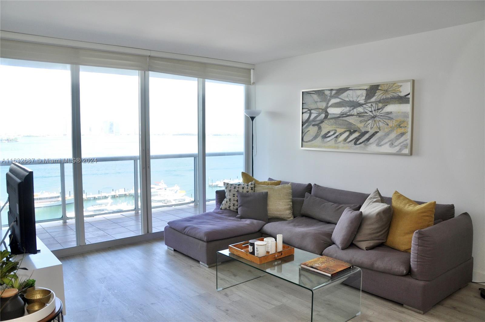 a living room with furniture and a floor to ceiling window