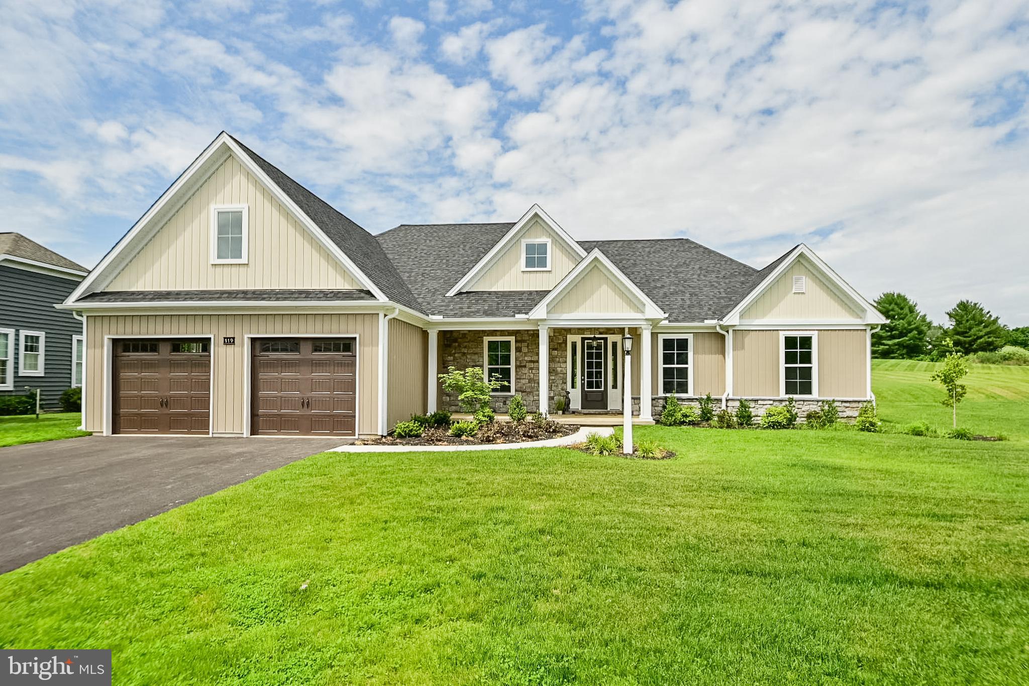 a front view of a house with a yard and trees