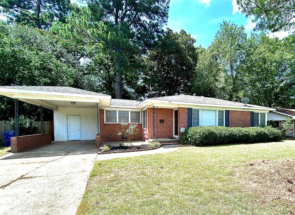 a front view of a house with a yard and potted plants