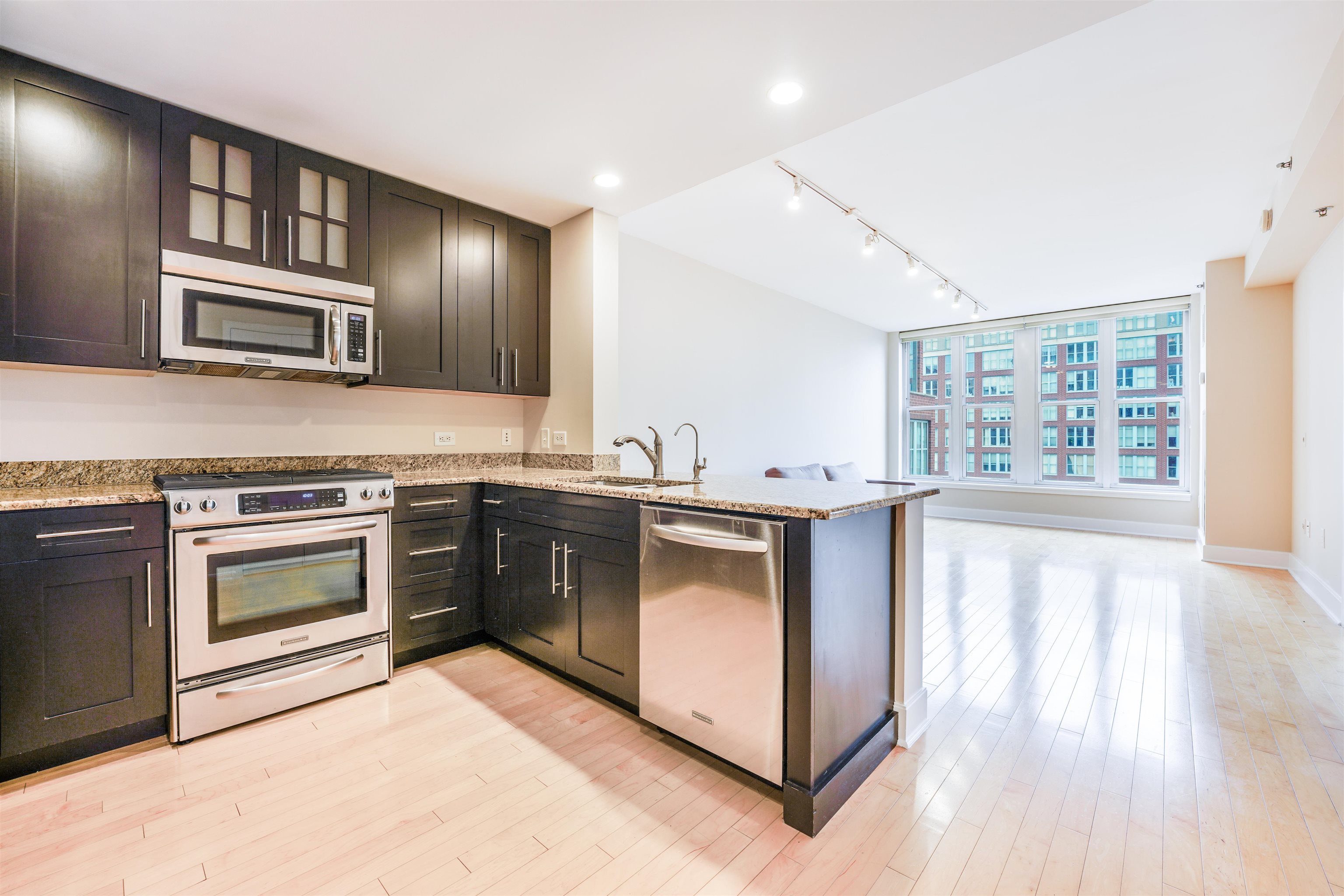 a kitchen with stainless steel appliances granite countertop a stove and a microwave