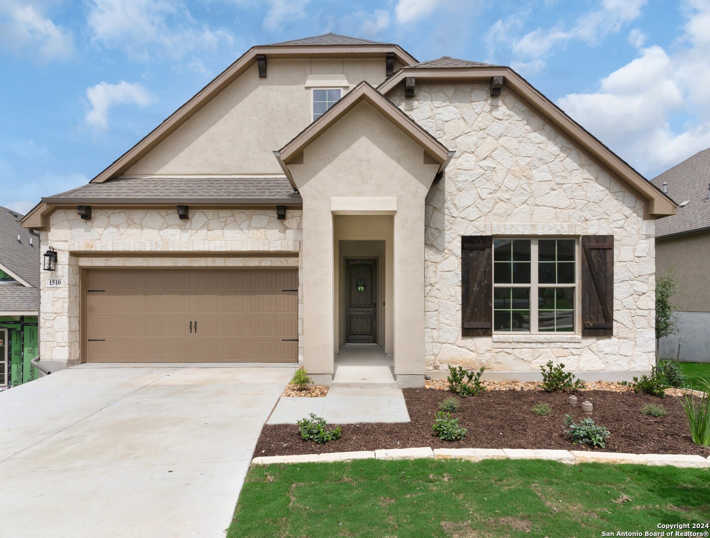 a front view of a house with a yard and garage