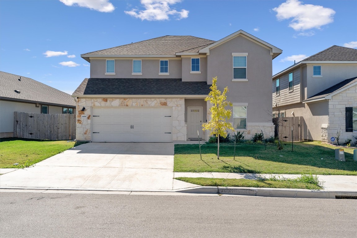 a front view of a house with a yard and garage