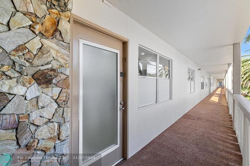 a view of a hallway with wooden floor and front door