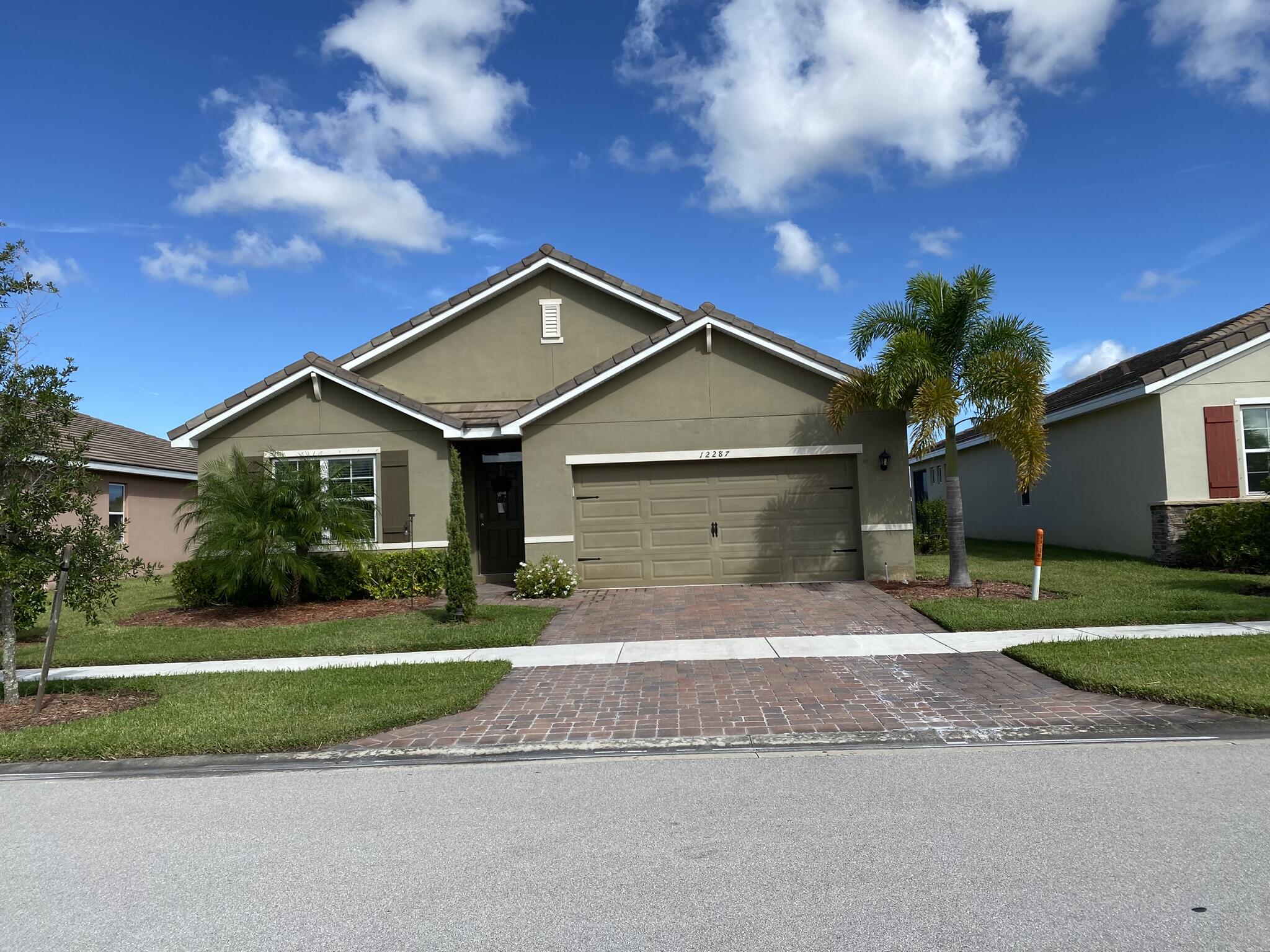 a front view of a house with a yard and garage