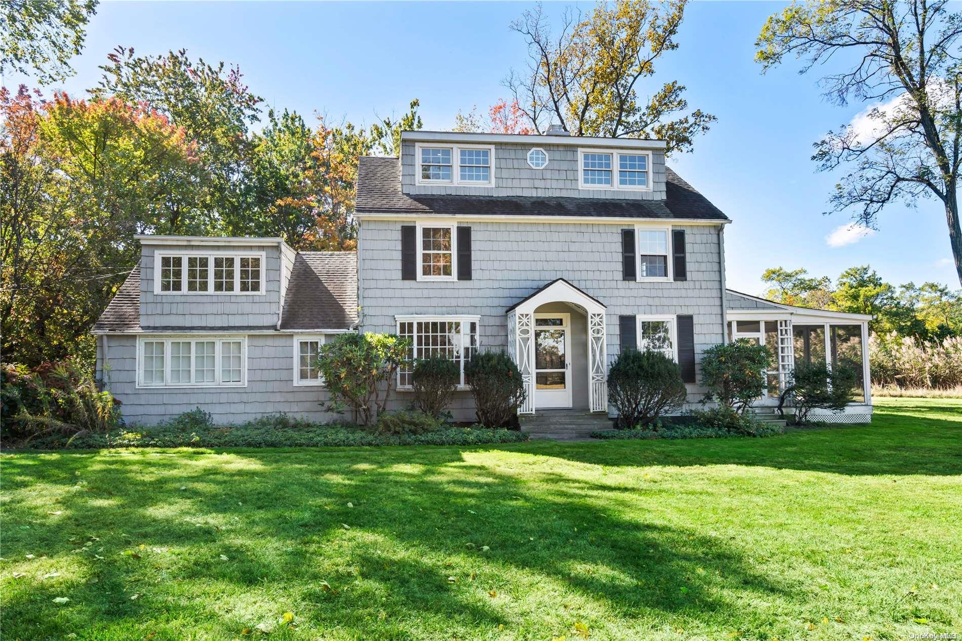 a front view of a house with a yard and trees