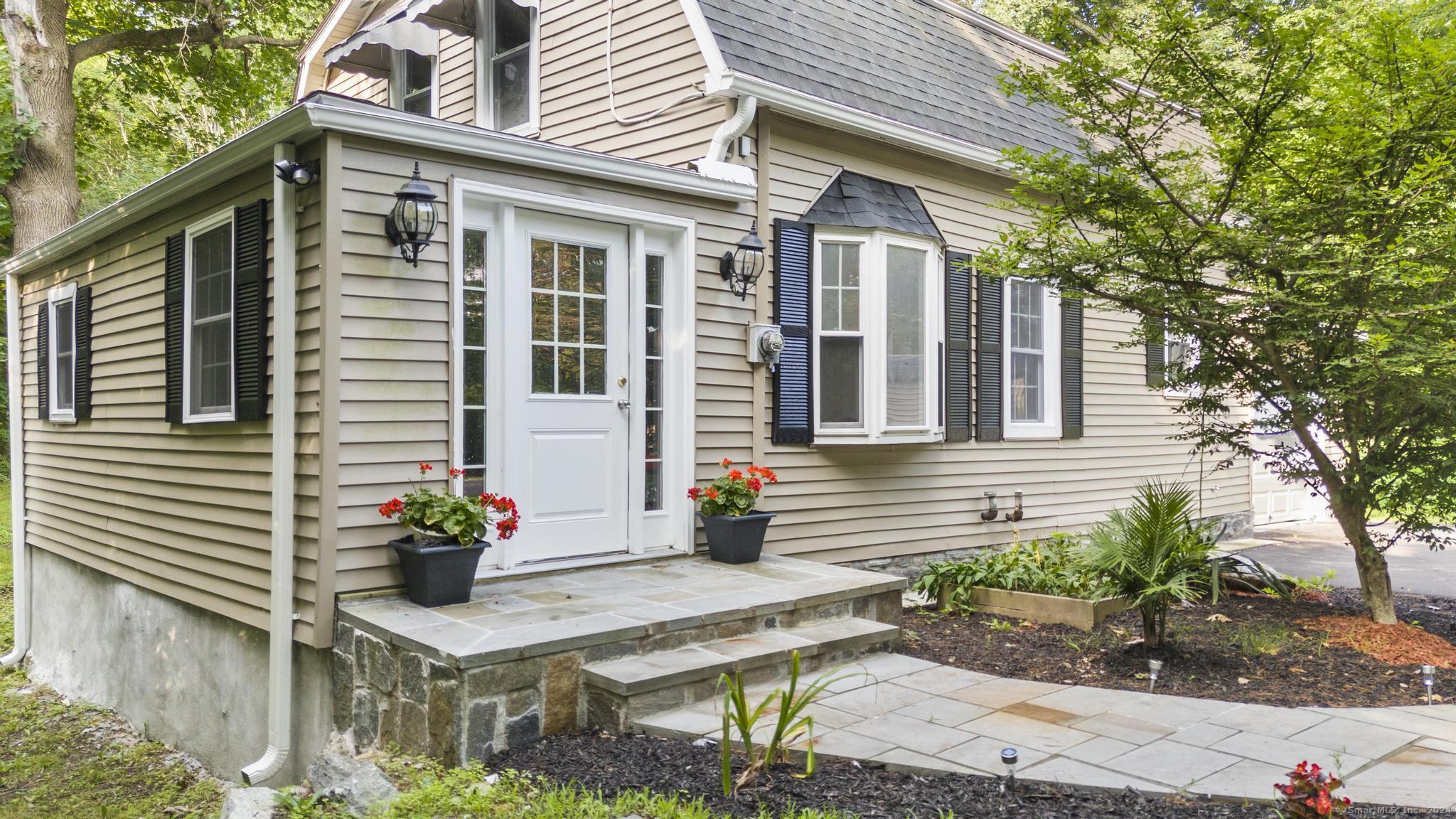 a front view of a house with plants