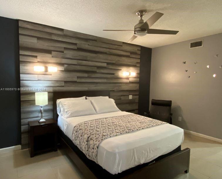 a bedroom with a bed and a ceiling fan