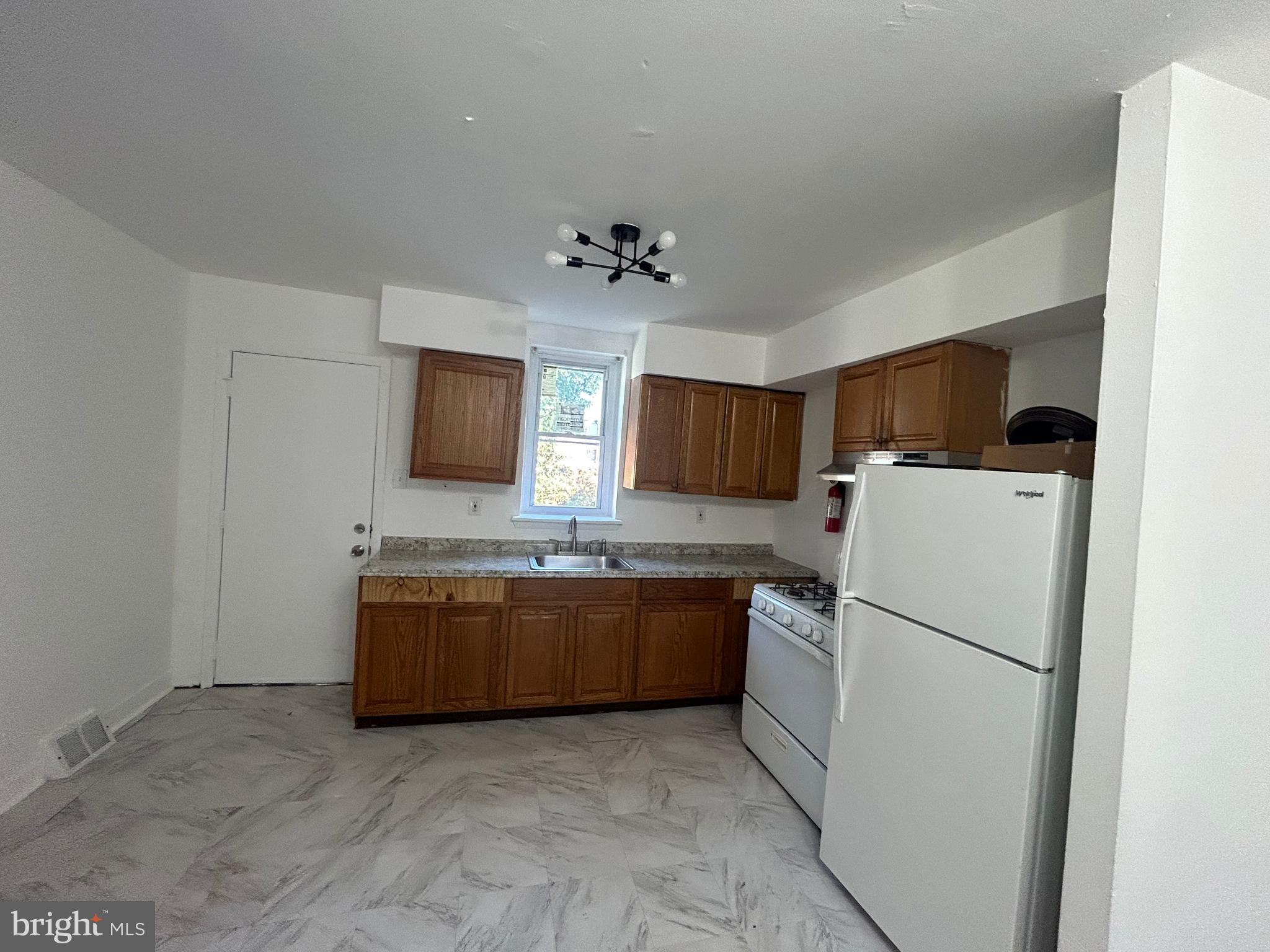 a kitchen with a refrigerator sink and white cabinets