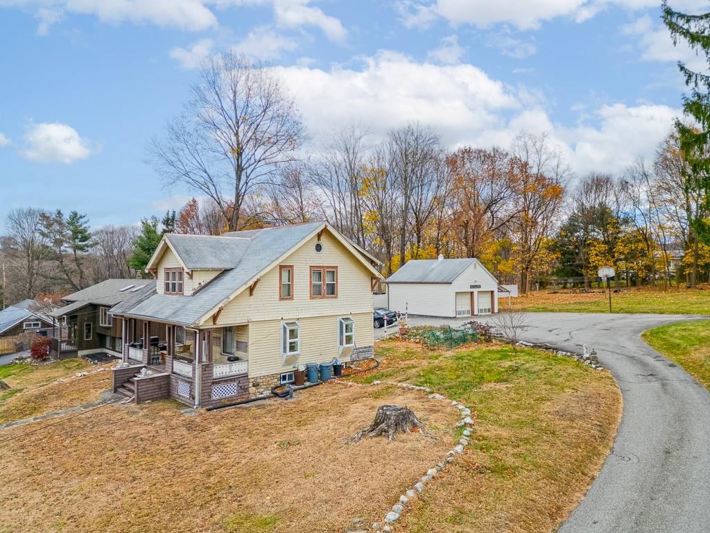 View of home's exterior with covered porch, an outdoor structure, and a garage