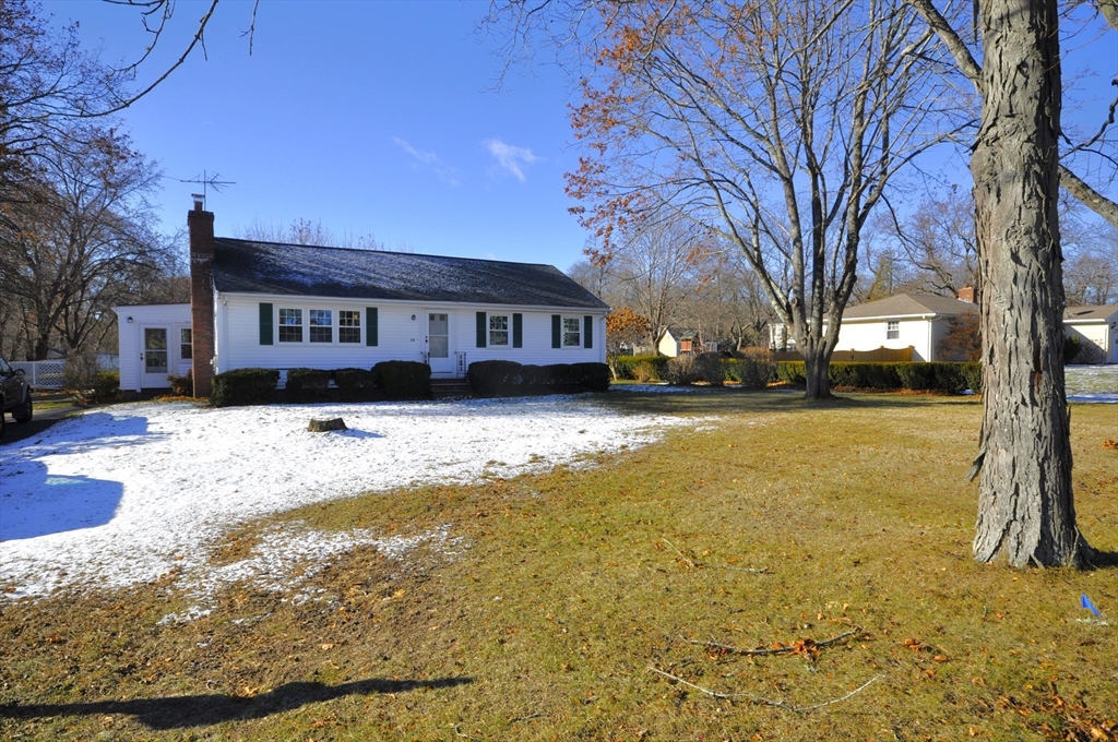 a view of large house with a yard covered with snow in front of house