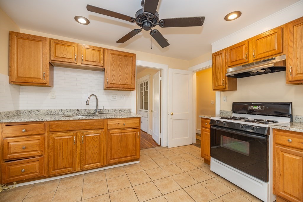 a kitchen with stainless steel appliances granite countertop a stove sink and cabinets