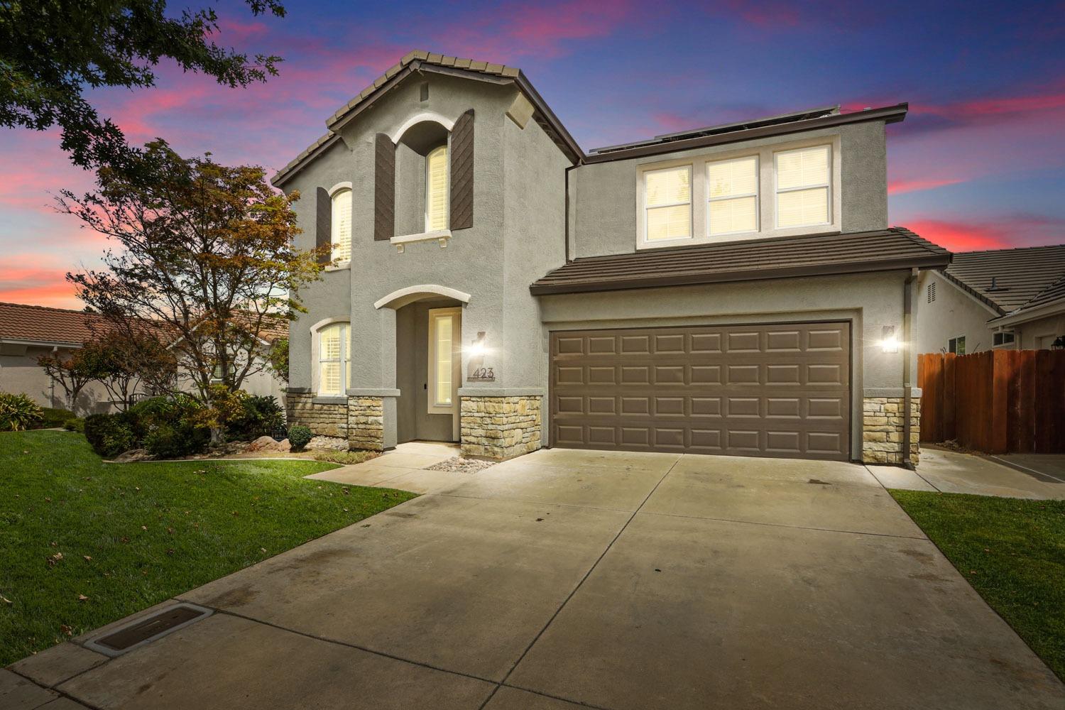 a front view of a house with a yard and garage