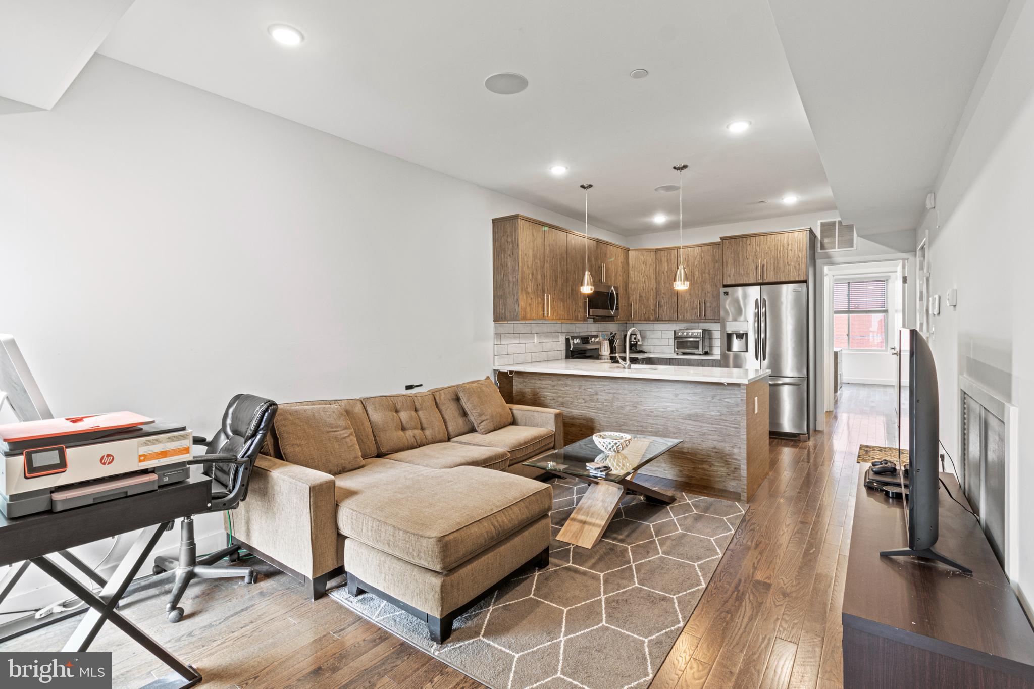 a living room with stainless steel appliances kitchen island granite countertop furniture and a view of kitchen