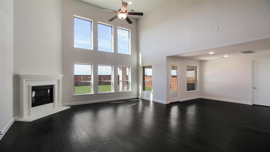 a view of an empty room with wooden floor and a fireplace