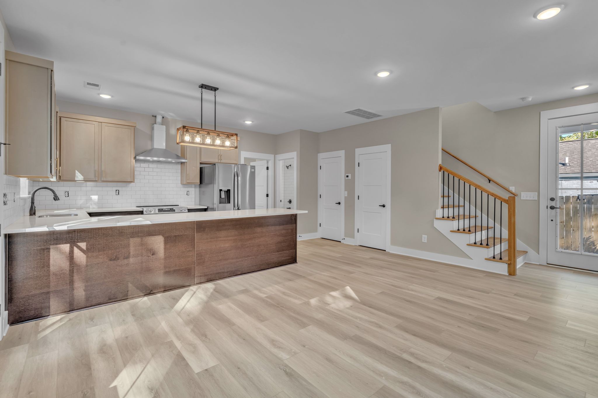 a large kitchen with kitchen island a sink stainless steel appliances and cabinets