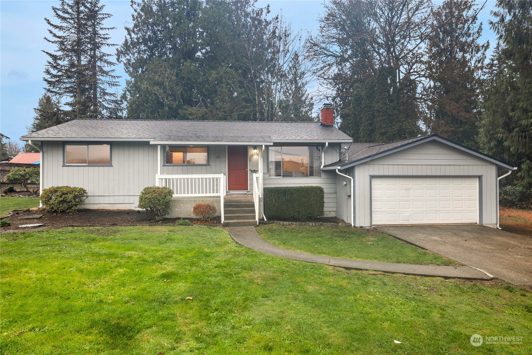 a view of a house with a yard and large tree