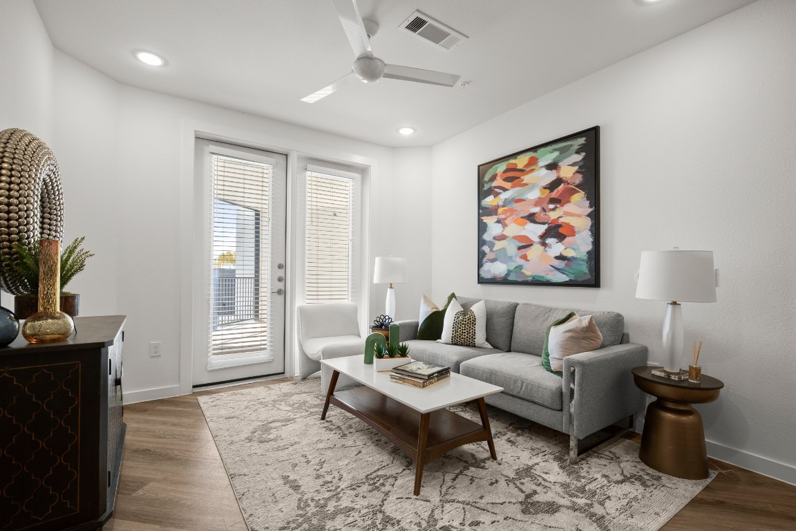 a living room with furniture a flat screen tv and a window