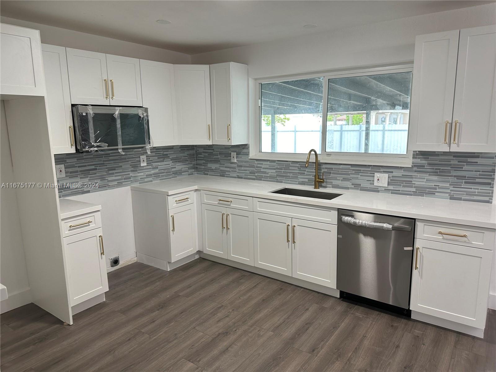 a kitchen with granite countertop white cabinets and white appliances