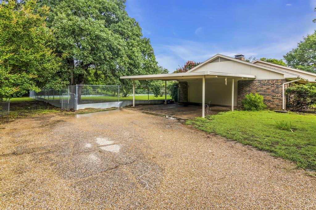 a view of a house with a yard and large tree