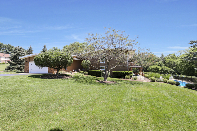 a view of a house with a yard and sitting area