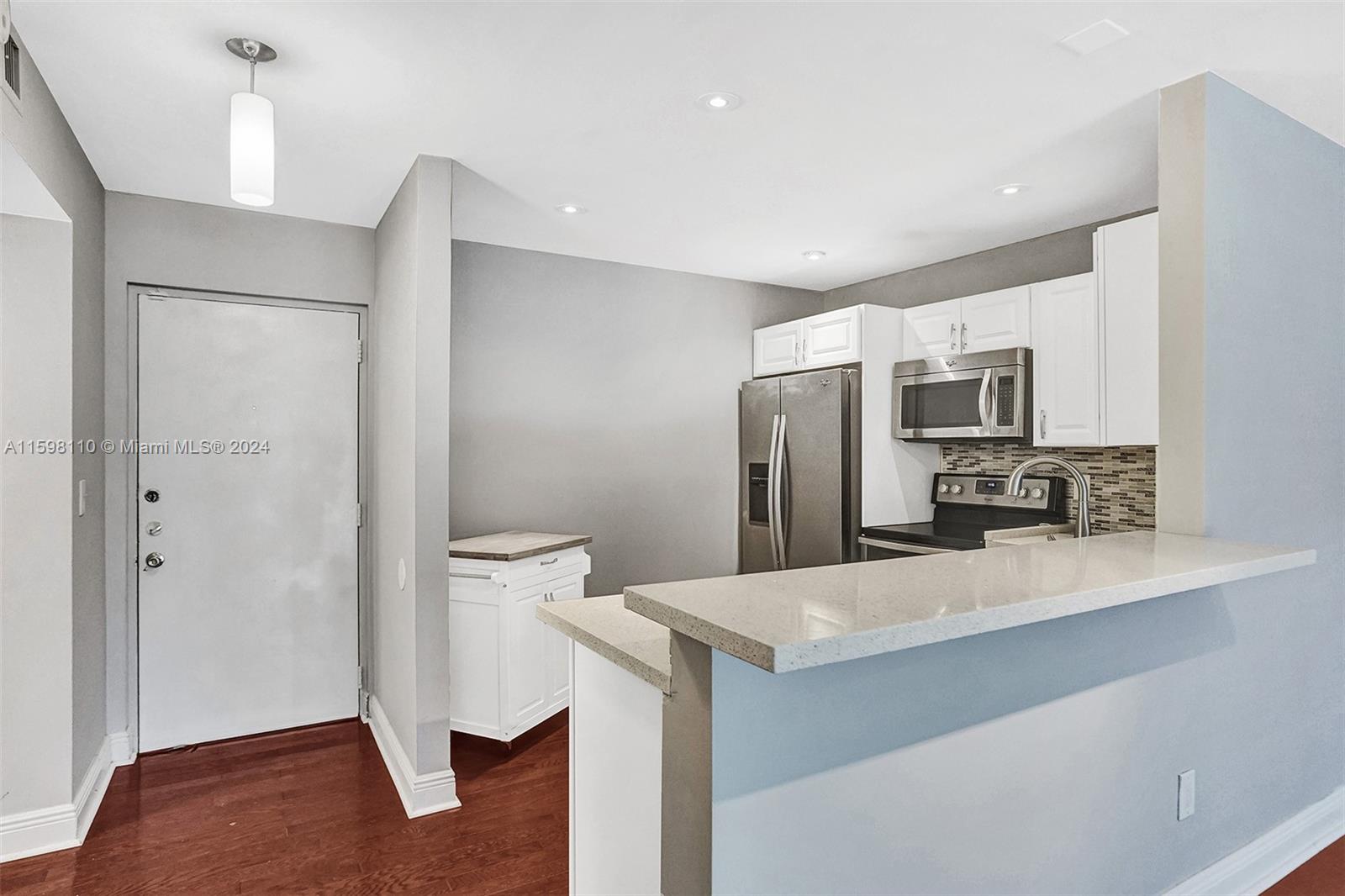 a kitchen with stainless steel appliances a refrigerator and a stove top oven