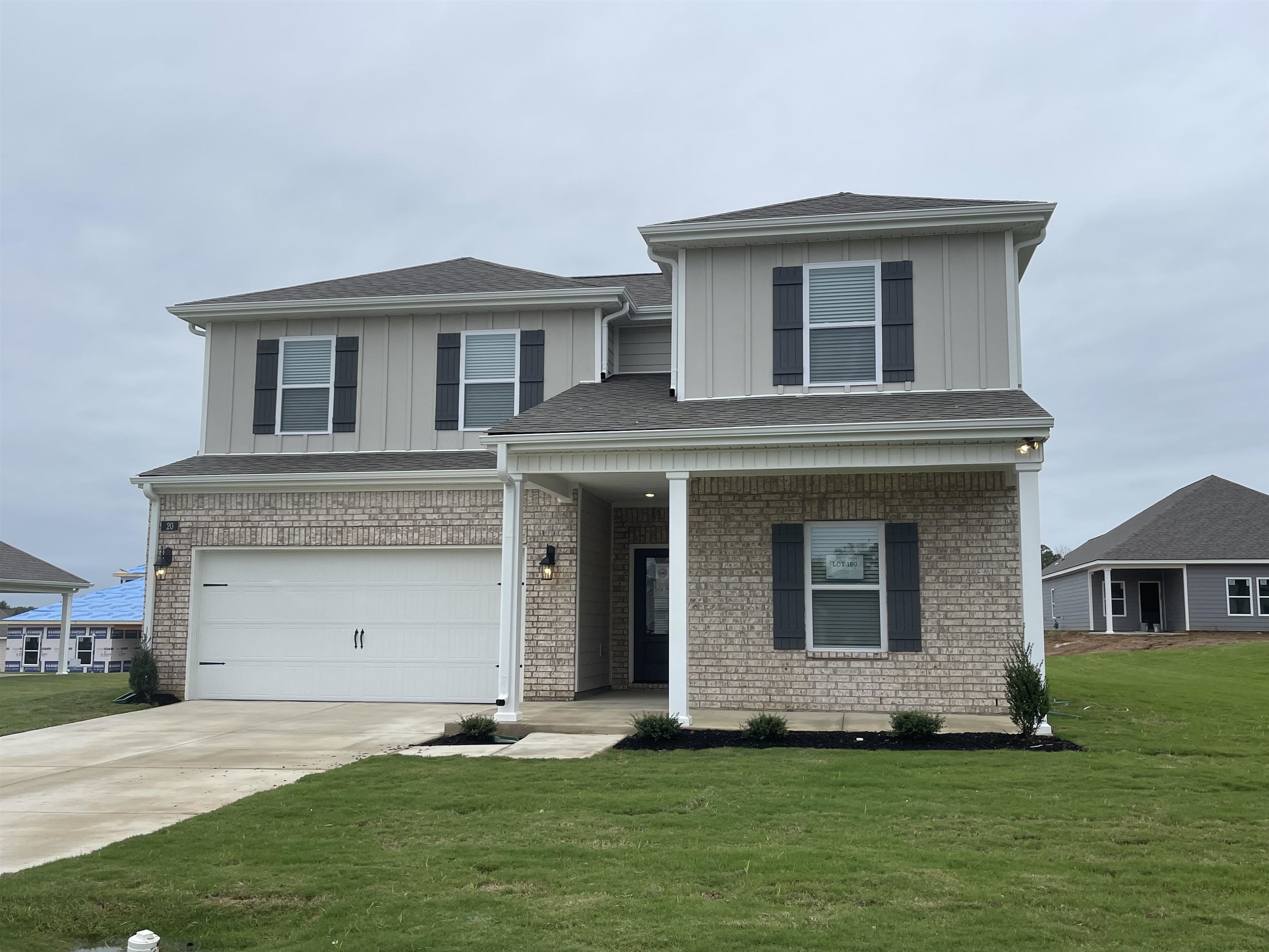 a front view of a house with a garden and yard