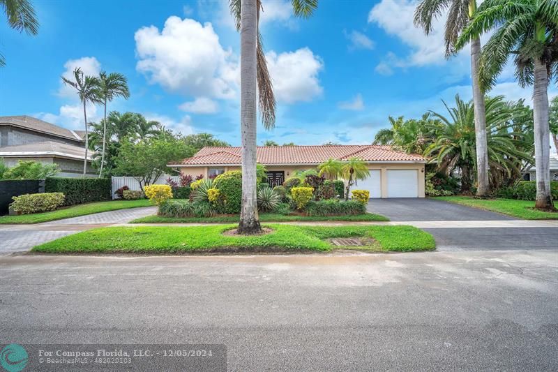 a view of a house with a big yard and palm trees