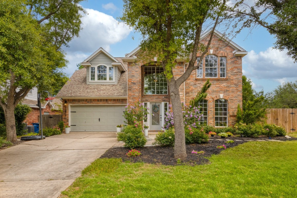 a front view of a house with a yard and trees