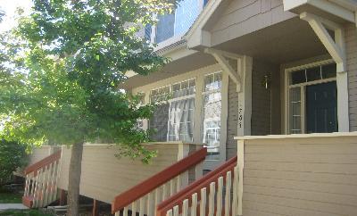 a view of balcony with two plants and wooden fence